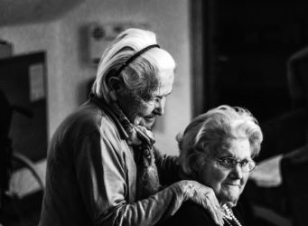 old woman sitting and comforting each other