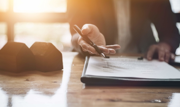 Photo of real estate agent offering customer to sign an agreement